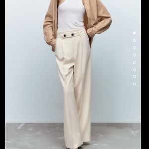 High waisted pants with front pleats and tonal belt with buttons.